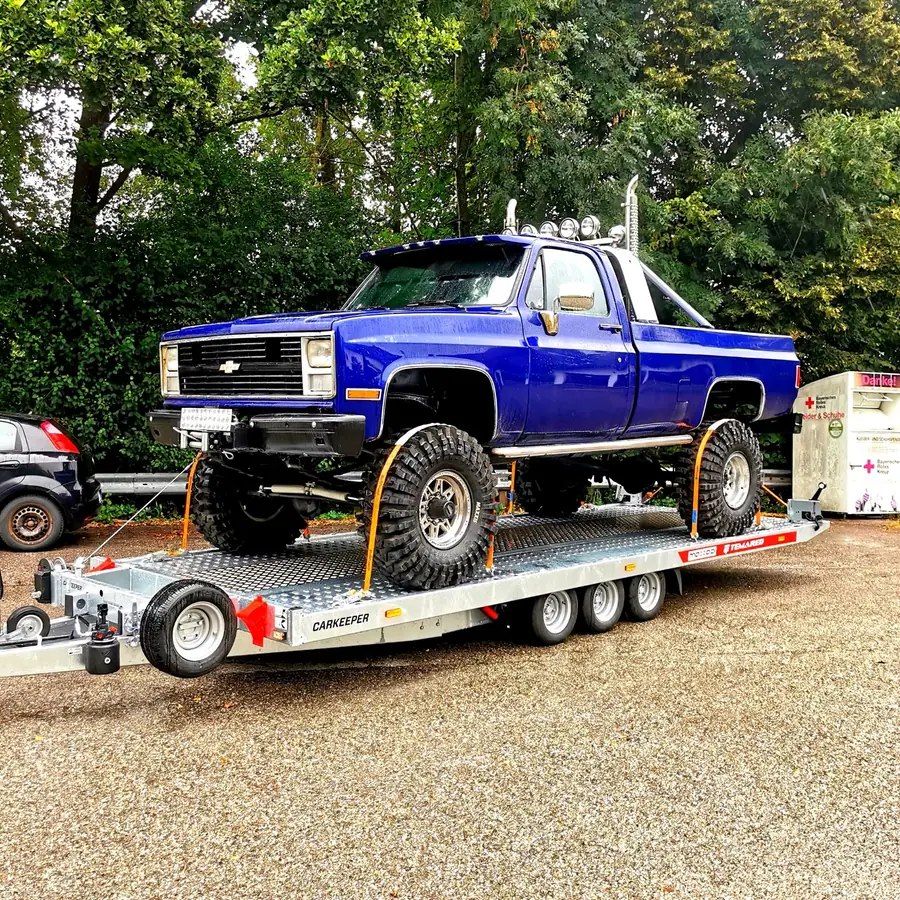 Blauer höhergelegter Chevrolet Pickup auf dem Transportanhänger
